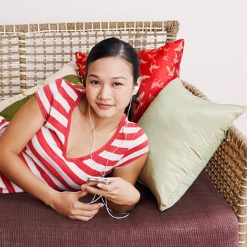 Portrait of a young woman listening to an MP3 player