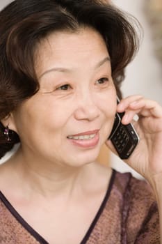 Close-up of a mature woman talking on a mobile phone and smiling