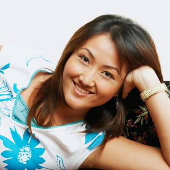 Portrait of a young woman lying on a couch and smiling