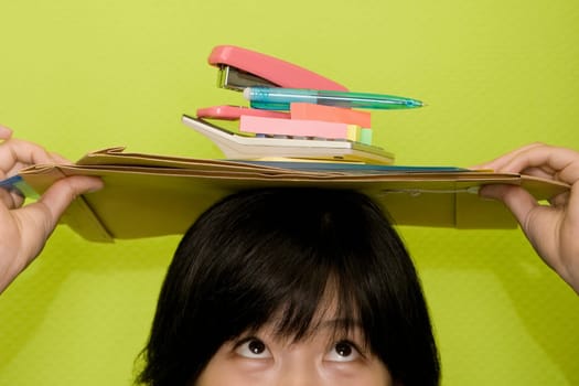 Young woman holding office stationeries on her head