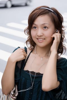 Close-up of a young woman adjusting headphones and looking up