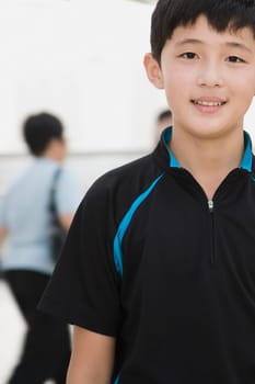 Portrait of a teenage boy standing in a corridor and smiling