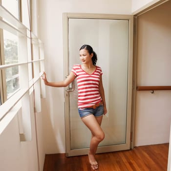 Young woman standing at a doorway and smiling