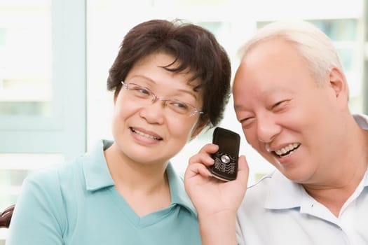 Mature couple listening to a mobile phone