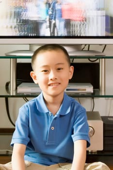 Portrait of a boy smiling in front of a television