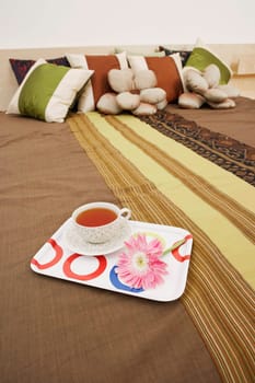 Tea cup and a tray on the bed