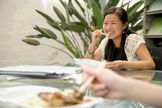 Female office worker having lunch and smiling