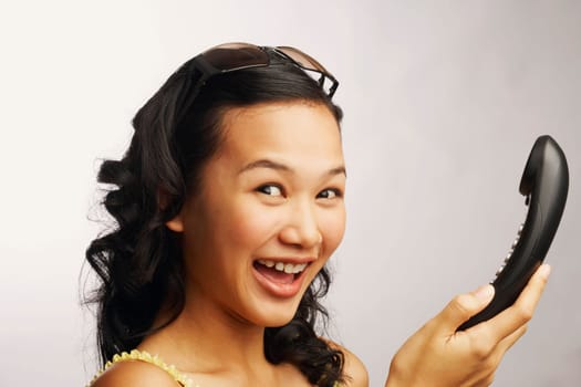 Portrait of a young woman holding a telephone and smiling