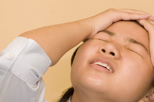 Close-up of a young woman with her head in her hands