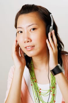Portrait of a young woman wearing headphones and listening to music