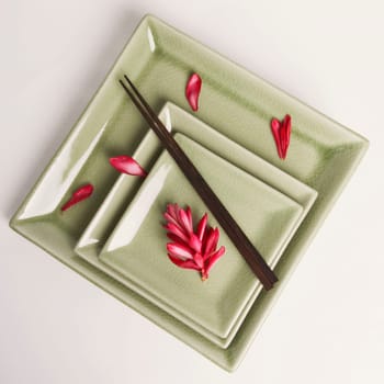 High angle view of flower petals and chopsticks in a plate