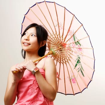 Close-up of a young woman holding a parasol and looking away