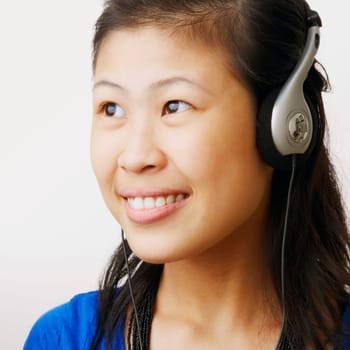 Close-up of a young woman wearing headphones and listening to music