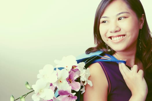 Close-up of a young woman carrying flowers in a shopping bag