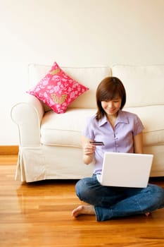 Young woman shopping online with a credit card