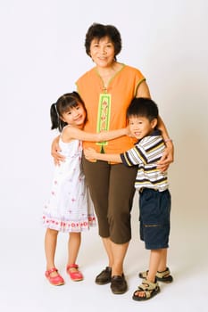 Portrait of a mature woman standing with her grandson and a granddaughter