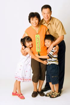 Portrait of a senior man and a mature woman standing with their grandchildren