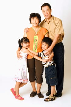 Portrait of a senior man and a mature woman standing with their grandchildren