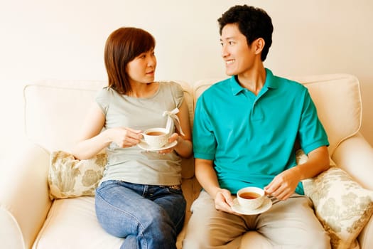 Young couple sitting on a couch and looking at each other