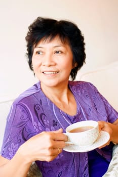 Close-up of a mature woman holding a cup of tea