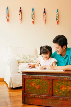 Young man teaching his daughter to color