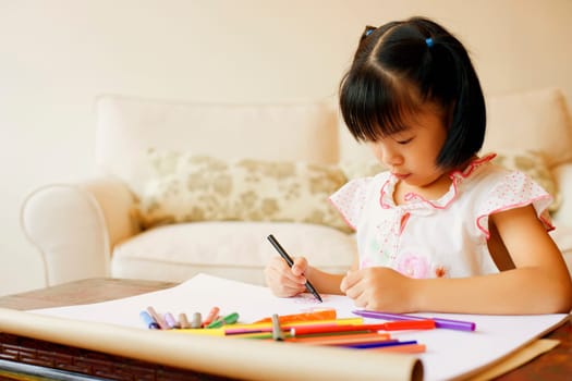 Girl drawing in a coloring book