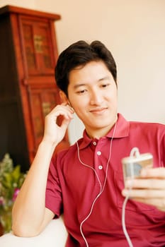Close-up of a young man listening to an MP3 player