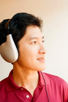 Close-up of a young man wearing headphones and listening to music