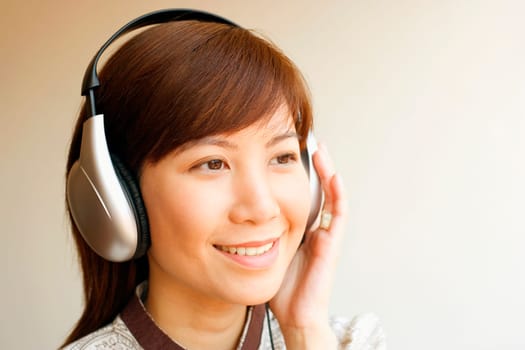Close-up of a young woman wearing headphones and listening to music