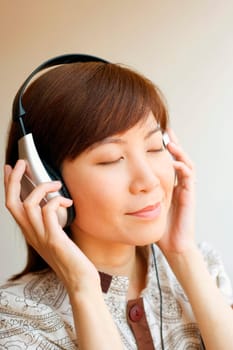 Close-up of a young woman wearing headphones and listening to music