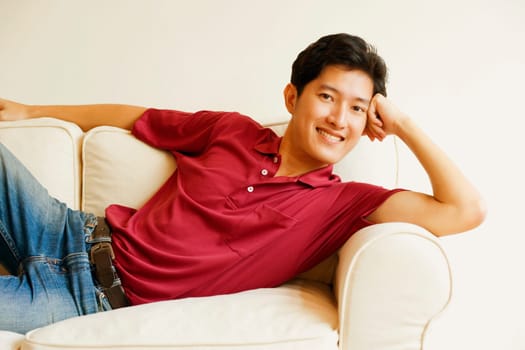 Portrait of a young man lying on a couch and smiling