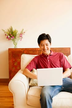 Young man sitting on a couch and using a laptop