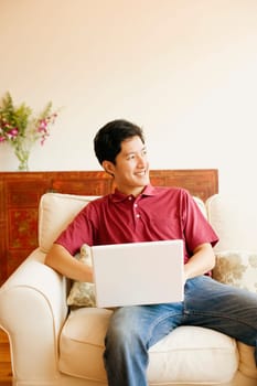 Young man sitting on a couch with a laptop
