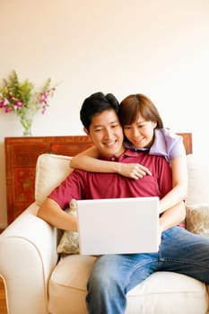 Young couple using a laptop and smiling