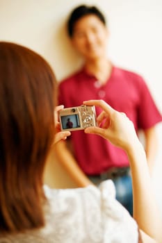 Rear view of a young man taking a picture of a young woman