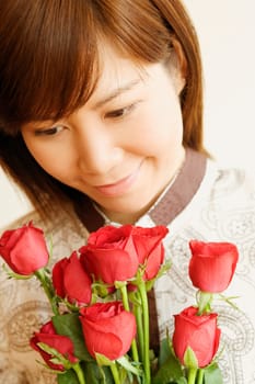 Close-up of a young woman holding a bouquet of red roses