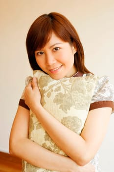 Portrait of a young woman holding a pillow