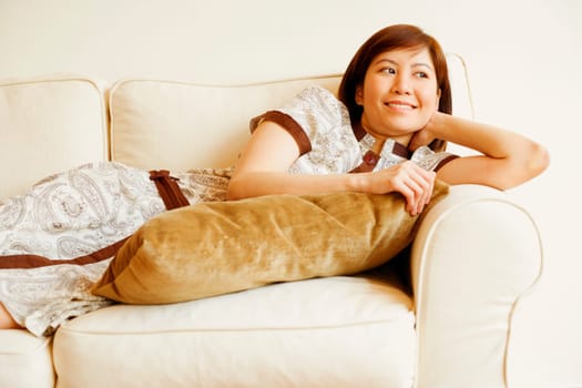 Close-up of a young woman lying on a couch and smiling