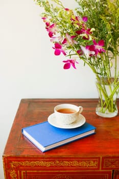 Close-up of a cup on a diary near a vase