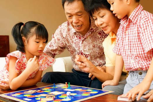Close-up of a girl and a boy playing game with their grandparents