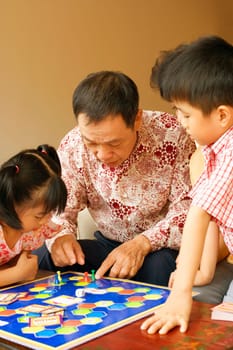 Close-up of a senior man playing a game with his grandchildren