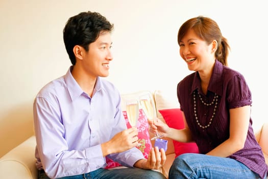 Close-up of a couple smiling and toasting champagne flutes