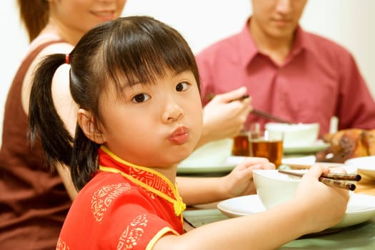 Portrait of a girl eating with chopsticks
