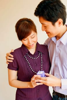 Close-up of a young couple standing together and holding a jewelry box