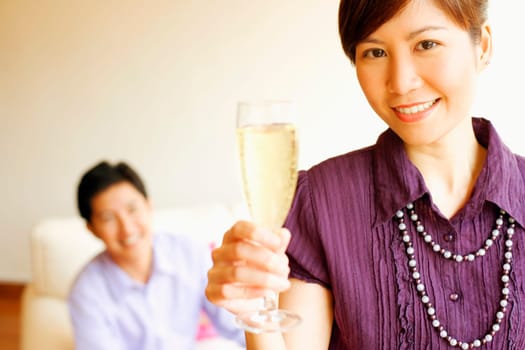 Portrait of a young woman smiling and holding a champagne flute