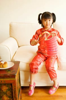 Portrait of a girl sitting and holding a Chinese lantern