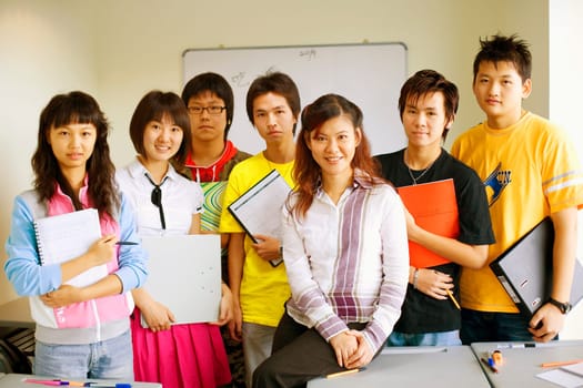 Portrait of a professor smiling with her students in a classroom