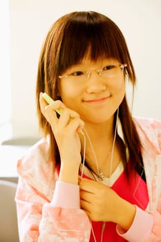 Close-up of a teenage girl listening to an MP3 player in the classroom