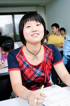 Close-up of students sitting in a classroom and smiling