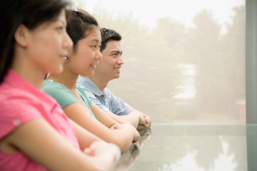 Three office workers sitting in a conference room and smiling